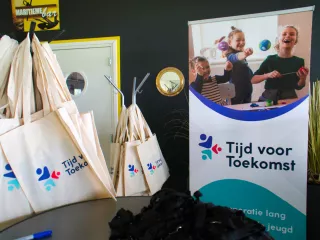 Tasjes en banner van tijd voor toekomst bij de ingang van de middag